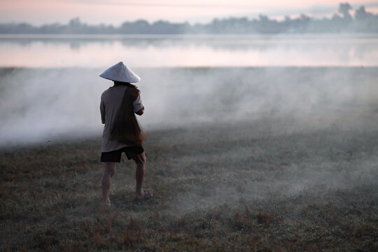 Silhouette of traditional fishermen casting net at golden sunrise in Sakon Nakhon, Isan, Thailand. Capturing authentic rural Asian lifestyle, culture, and fishing for daily sustenance in tranquil lake