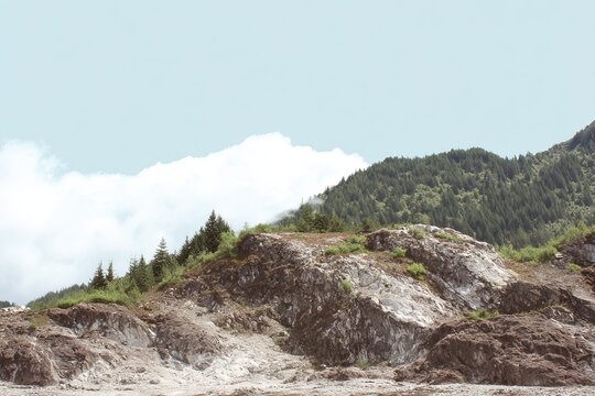 Rugged Mountain Landscape with Clouds and Forested Slopes.