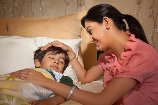 Mother putting son to sleep