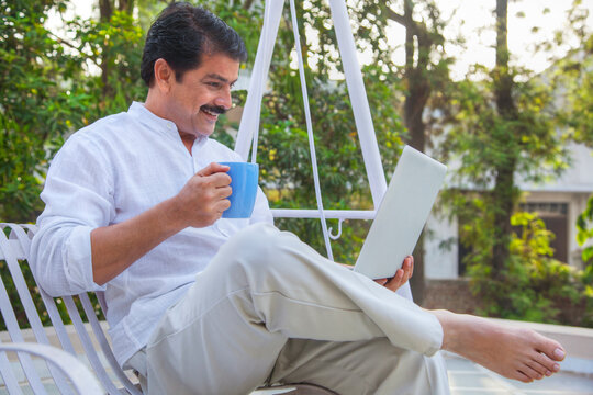 Man with laptop and mug of tea