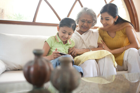 Multigeneration family looking at picture on mobile phone