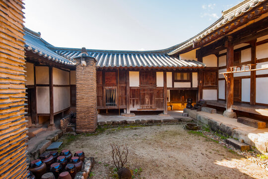 Traditional Korean hanok vernacular architecture panoramic courtyard view featuring traditional earthenware jars, chimney, and timber structures