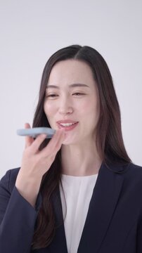 スマホで音声入力するビジネスウーマン