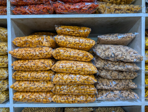 Packaged assorted nut snacks stacked on retail display shelves.