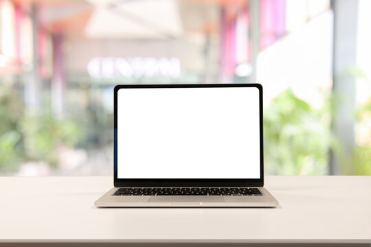 close up isolated on blank white screen display of laptop computer on table inside office room for add content of design banner , website or template or online shopping e-commerce concept