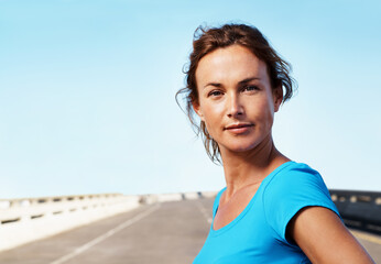 Obraz premium Portrait, woman and outdoor in city with fitness, confident and getting ready for cardio exercise. Space, serious female person and runner on bridge with wellness, vitality and workout in street.