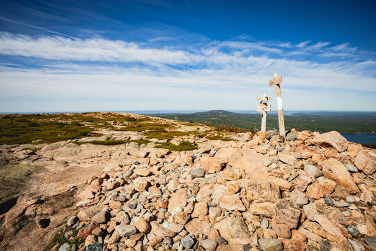 Scenic view from a rocky mountain summit with trail markers