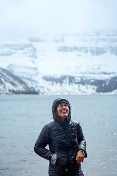 Smiling woman enjoying winter scenery at Cameron Lake in Waterton park