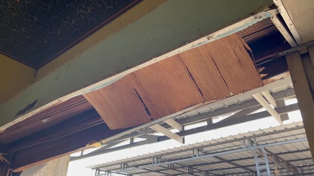 Broken rolling door with damaged panels in old building