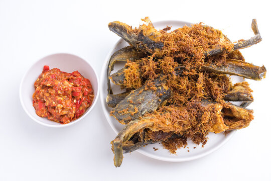 Deep fried crispy catfish served with spicy red chili paste sambal isolated on white background
