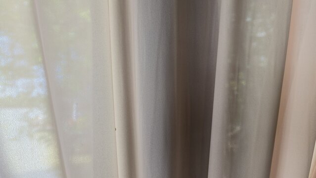 Luxury shimmering gold sheer curtain texture background. Close-up of elegant translucent silk drapery folds with glamorous metallic sheen, presenting a soft textile backdrop.