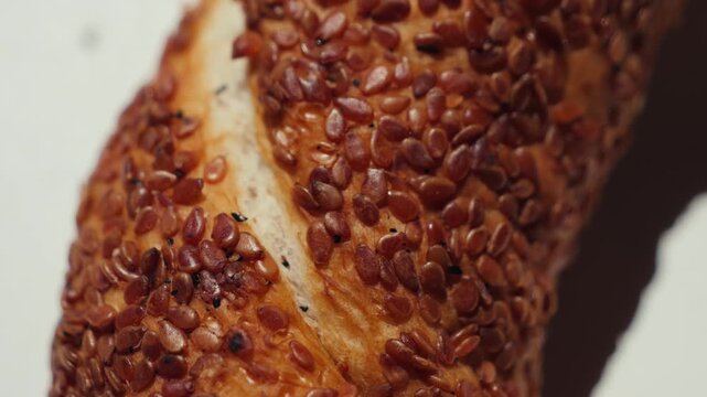 Freshly baked Turkish simit covered with roasted sesame seeds in close-up. Traditional ring-shaped bread with a crispy golden crust, popular street food and bakery product from Turkey. High quality 4k