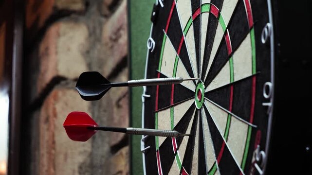 Players throwing darts at a dartboard in a bar during a friendly game. High quality 4k footage