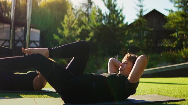 Elderly women practicing outdoor Pilates exercises on yoga mats in slow motion, focusing on core strength, balance, flexibility, and healthy active aging together
