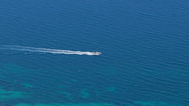 Speedboat crossing turquoise coastal waters off Possidi Beach