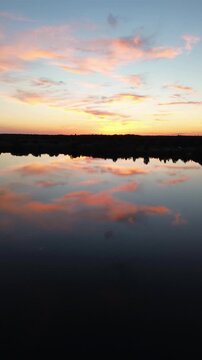 Magical sunset with clouds reflecting over a calm lake in insta format