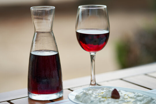Close-up of a glass of red wine and a carafe on a wooden table