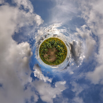 simple little tiny planet without buildings in blue sky with sun and beautiful clouds. Transformation of spherical panorama 360 degrees. Spherical abstract aerial view. Curvature of space.