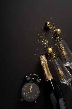 Happy New Year 2027 celebration scene with champagne, glasses, clock and gold decorations on vertical black backdrop
