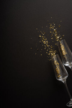 Happy New Year 2027 celebration with champagne glasses and gold confetti on vertical black background