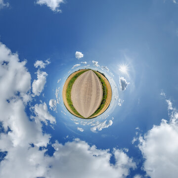 simple little tiny planet without buildings in blue sky with sun and beautiful clouds. Transformation of spherical panorama 360 degrees. Spherical abstract aerial view. Curvature of space.