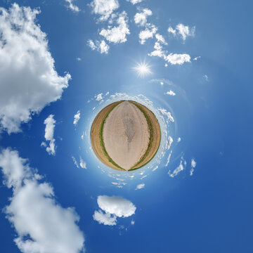 simple little tiny planet without buildings in blue sky with sun and beautiful clouds. Transformation of spherical panorama 360 degrees. Spherical abstract aerial view. Curvature of space.
