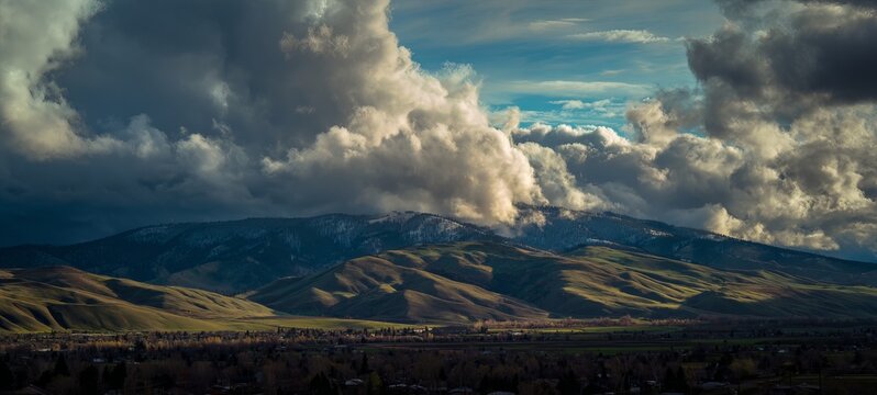 Dramatic Sky Over Rolling Hills - A Landscape of Light and Shadow.