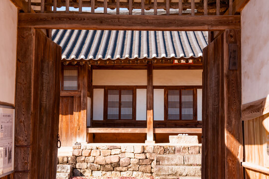 Traditional Korean hanok vernacular architecture framing internal courtyard view through open wooden entrance gate