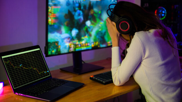 Game over you lose. Angry Asian gamer with gaming headphones playing video game on computer PC at home feeling sad disappointed about NFT game losing graph investors sulk down