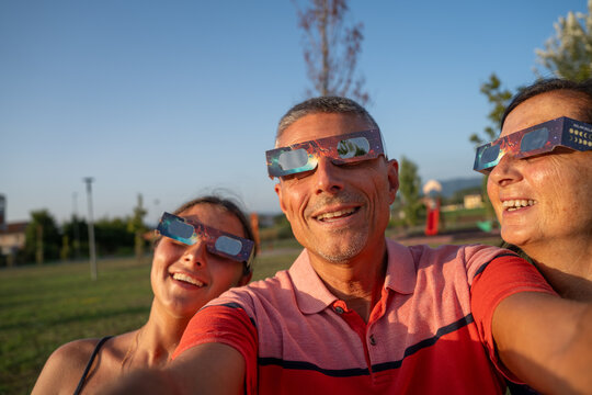 Parents and child watching total solar eclipse together with wonder and emotion