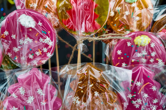 A Christmas tree stands tall, adorned with lights and ornaments. Colorful candies wrapped in clear plastic are displayed nearby, celebrating the holiday spirit