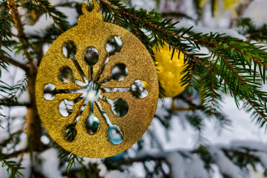 A decorated Christmas tree stands in the snow, showcasing colorful ornaments and a winter setting that highlights the festive time of year