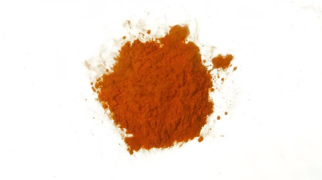 Top-view close-up macro shot of a foggy cloud of orange dust flowing in a petri dish over a pile of powder on a white canvas
