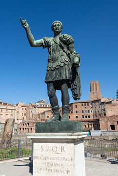 Italy, Rome: statue of the Roman emperor Trajan and Trajan's Market in the background, Trajan's Forum, Foro di Traiano, with the letters SPQR, Senatus populusque romanus, The Roman Senate and People