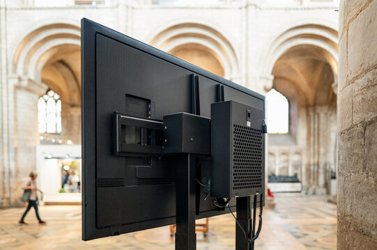 Shallow focus of the rear of a large plasma TV located in a famous English cathedral. The screen displays the main service to the congregation who may be too far away to see the service properly.