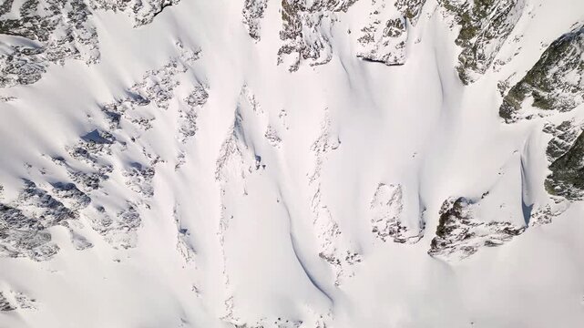 Aerial view of the snowy slopes and rugged terrain surrounding the Schonbielhutte SAC in Zermatt, Wallis, Switzerland.