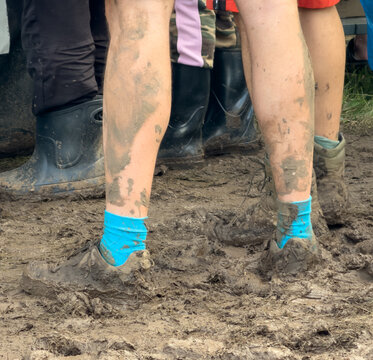 Muddy legs and boots in a messy, wet environment