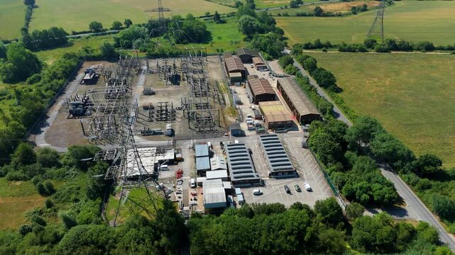 Aerial view of National Grid Thorpe Marsh Substation featuring electrical transformers and industrial buildings surrounded by green fields in Barnby Dun, England, United Kingdom.