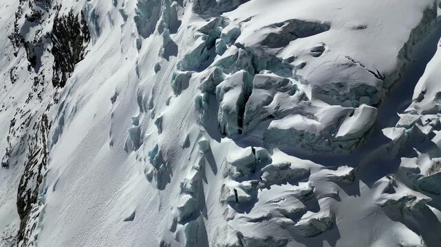Aerial view of the crevassed glacier near Schonbielhutte SAC with deep blue ice formations and snow-covered slopes in Zermatt, Wallis, Switzerland.