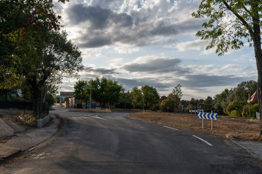 Country road curve with chevron sign and intersection in Septfonds, Tarn-et-Garonne, France