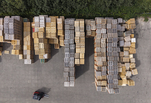 Aerial view of the Foresco Middenmeer facility featuring organized rows of stacked wooden pallets and a forklift on the asphalt ground in Middenmeer, Noord-Holland, Netherlands.