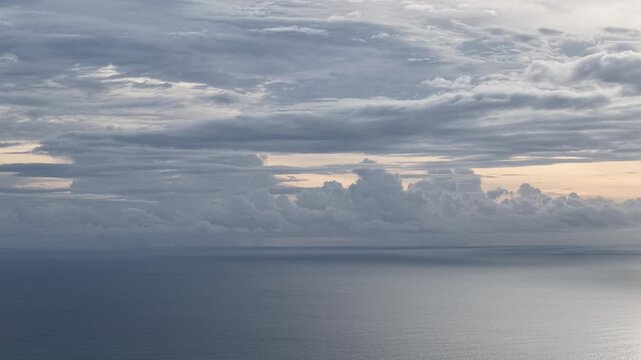 Aerial view of the vast ocean under a dramatic cloudy sky at sunset near the coast of Cemagi in Mengwi, Bali, Indonesia.