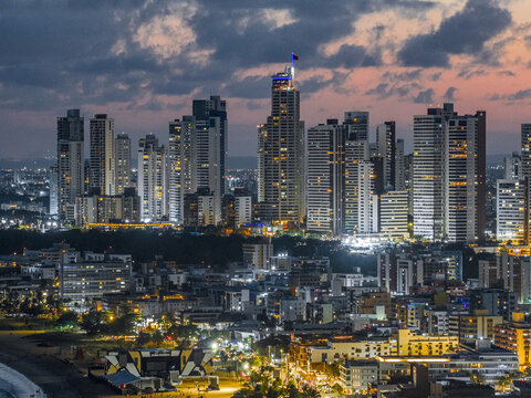 Aerial view of the illuminated skyline featuring high-rise buildings and coastal urban landscape at twilight in Joao Pessoa, State of Paraiba, Brazil.
