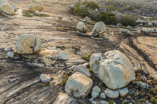 Aerial view of the unique granite boulder formations at Lajedo de Pai Mateus, set against a vast rocky landscape with sparse vegetation in Cabaceiras, Paraiba, Brazil.