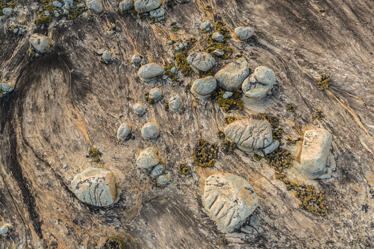 Aerial view of Lajedo de Pai Mateus featuring unique spherical rock formations and sparse vegetation scattered across the vast granite landscape in Cabaceiras, Paraiba, Brazil.