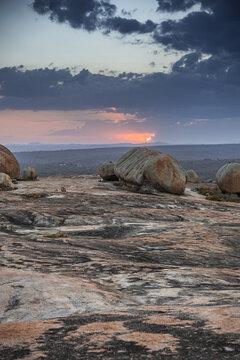 View of the unique rock formations of Lajedo de Pai Mateus at sunset with dramatic clouds over the landscape in Cabaceiras, Paraiba, Brazil.