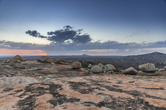 View of the unique rock formations at Lajedo de Pai Mateus during sunset, with large boulders scattered across the rocky terrain in Cabaceiras, Paraiba, Brazil.