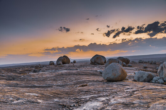 View of the unique rock formations at Lajedo de Pai Mateus under a vibrant sunset sky in the arid landscape of Cabaceiras, Paraiba, Brazil.