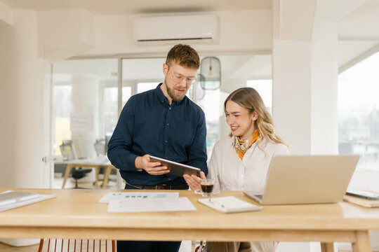 Man and woman analyze financial chart on tablet in the office