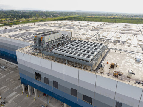 Aerial view of the HVAC cooling system on the roof of a modern data center building with solar panels in the background in Krakow, Lesser Poland Voivode, Poland.